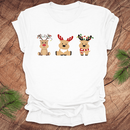 White t-shirt with cartoon reindeer design on a wooden surface