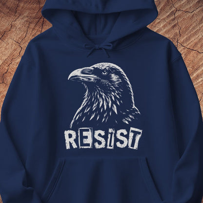 A navy blue pullover hoodie featuring a white graphic of a raven's head and the word 'RESIST' printed below it, displayed against a textured wood background.