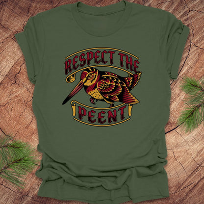 Green t-shirt with a bird graphic and 'Respect the Peent' text on a wooden surface.