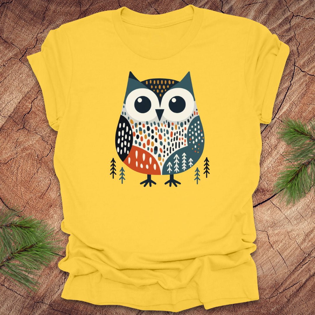 Yellow t-shirt with a colorful owl design on a wooden surface
