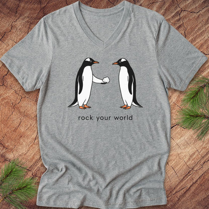 Gray v-neck t-shirt with two penguins and text, 'rock your world' on a wood background.