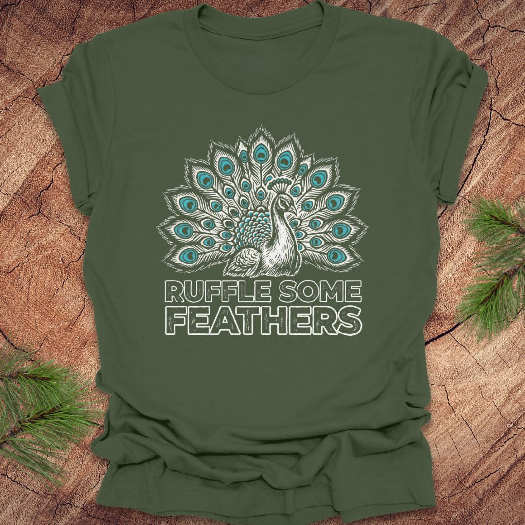 Green t-shirt with peacock design and 'Ruffle Some Feathers' text on a wooden surface.