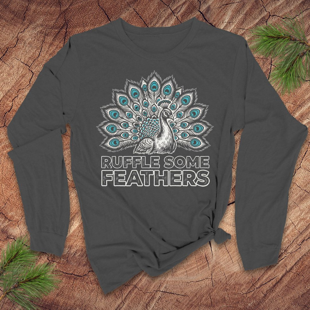 Dark gray long-sleeve shirt with peacock design and 'Ruffle Some Feathers' text on a wooden surface.