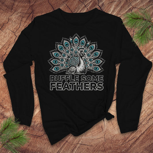 Black long-sleeve ttshirt with peacock design and 'Ruffle Some Feathers' text on a wooden surface.