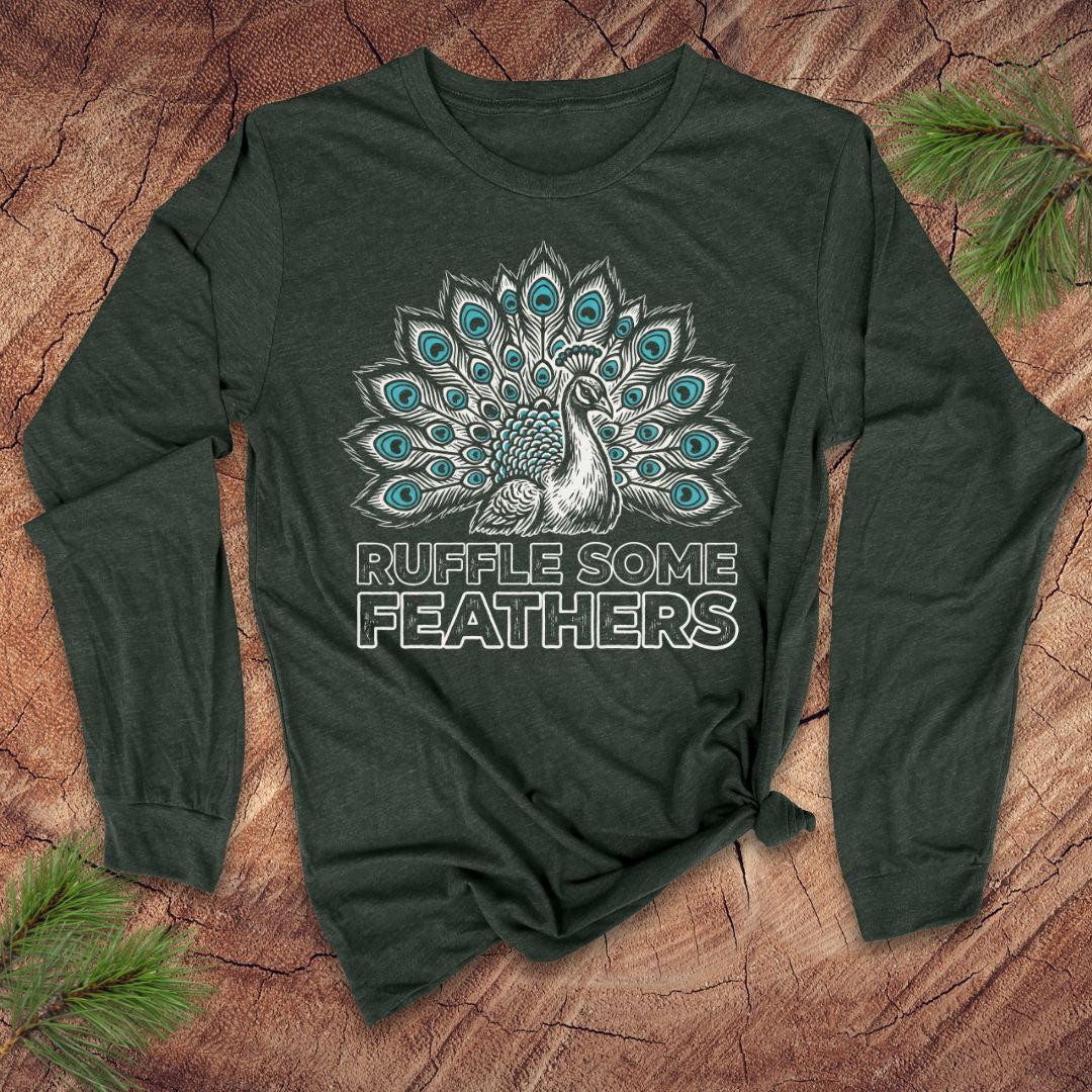 Green long-sleeve shirt with peacock design and 'Ruffle Some Feathers' text on a wooden surface.