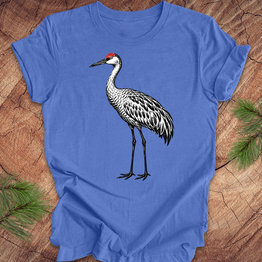 Blue t-shirt with a woodcut sandhill crane bird on a wood background.