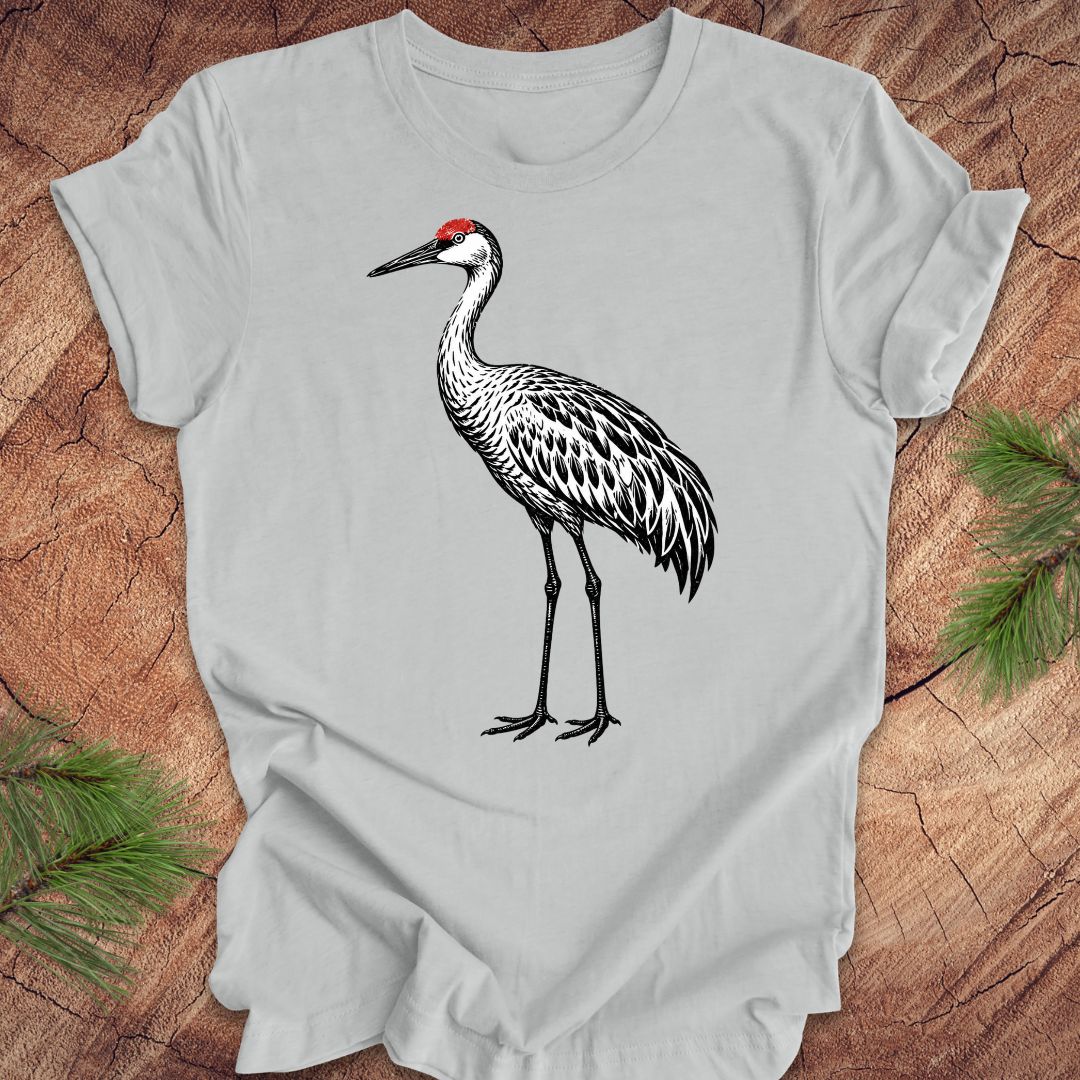 Gray t-shirt with a woodcut sandhill crane bird on a wood background.