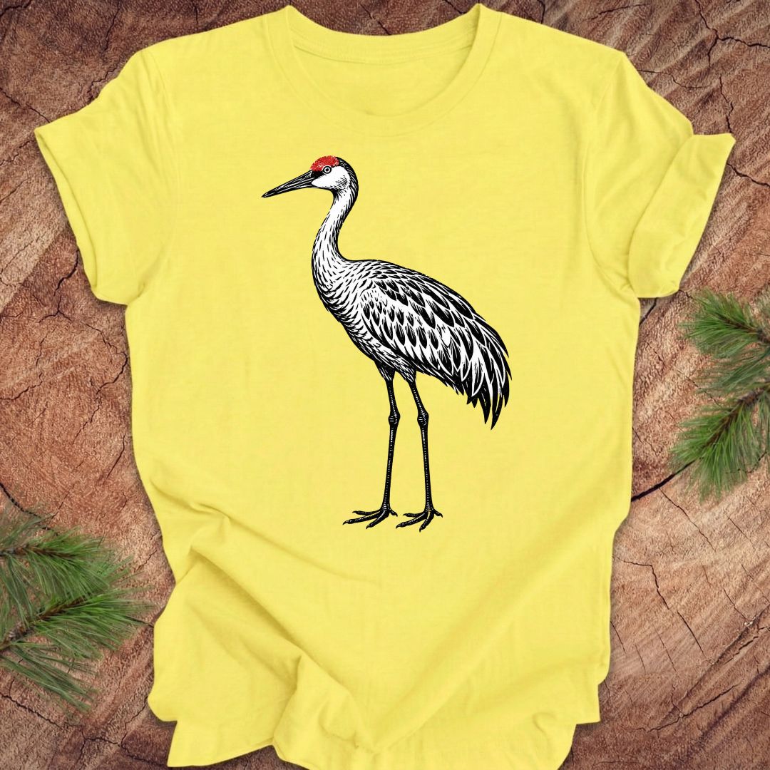 Yellow t-shirt with a woodcut sandhill crane bird on a wood background.