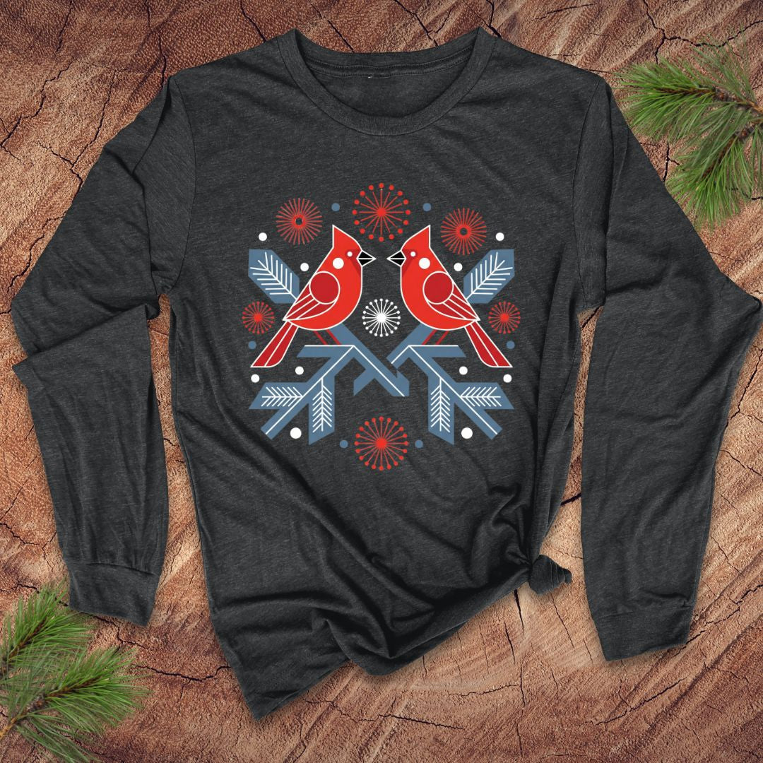 Dark gray long-sleeve shirt with red cardinals and blue snowflakes design on a wooden surface.