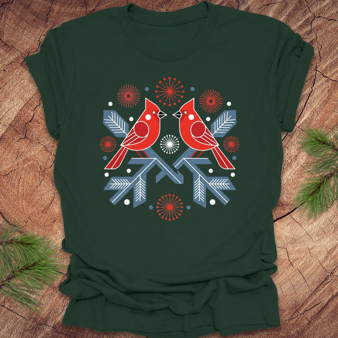 Green t-shirt with a folk art red cardinal birds design on a wooden surface