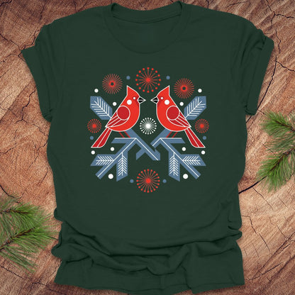 Green t-shirt with a folk art red cardinal birds design on a wooden surface