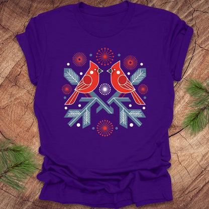 Purple t-shirt with a folk art red cardinal birds design on a wooden surface