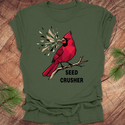 Green t-shirt with a red cardinal graphic and 'Seed Crusher' text on a wooden surface.