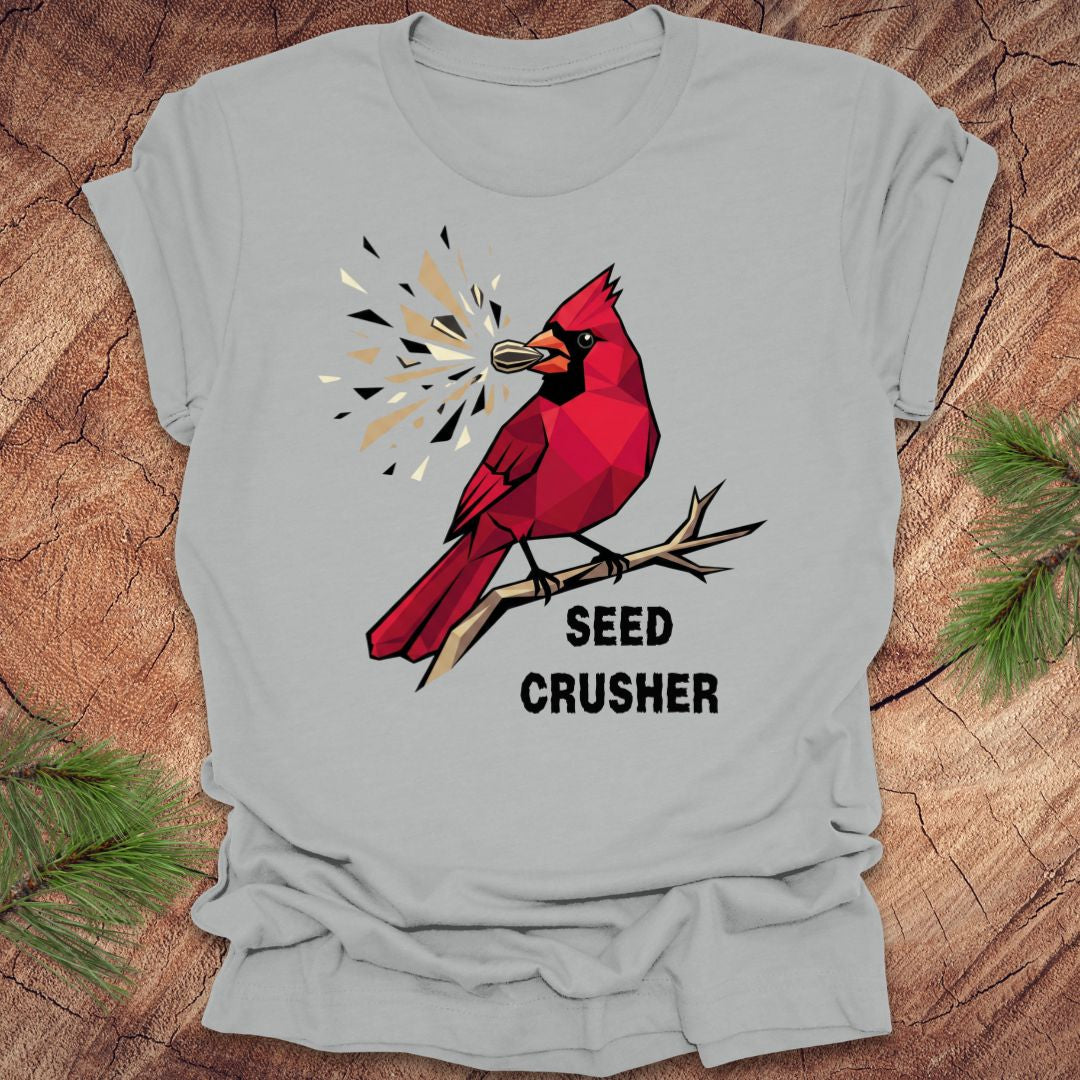 Gray t-shirt with a red cardinal graphic and 'Seed Crusher' text on a wooden surface.