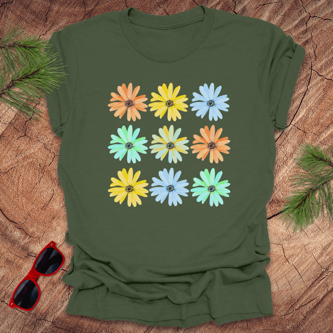 Green t-shirt with colorful flower pattern on a wooden surface with sunglasses.