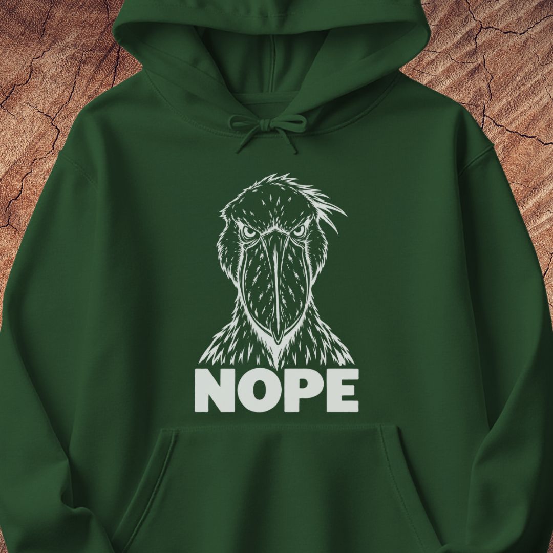 Forest green hoodie with a white line-art Shoebill staring straight ahead above the word NOPE, laid flat on a rustic wood background.