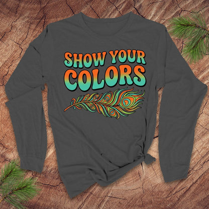 Gray long-sleeve shirt with 'Show Your Colors' text and peacock feather design on a wooden surface.