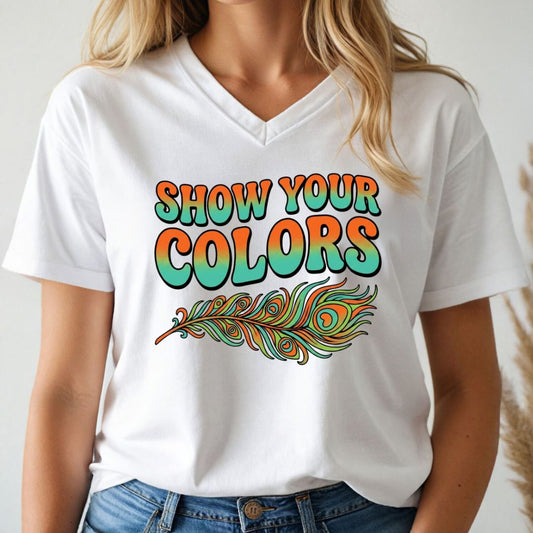 Person wearing a white v-neck t-shirt with 'Show Your Colors' and a peacock feather design.