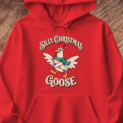Red hoodie with a goose in a Santa hat and teal scarf, wrapped in colorful Christmas lights under retro Silly Christmas Goose lettering, laid flat on a rustic wood background.