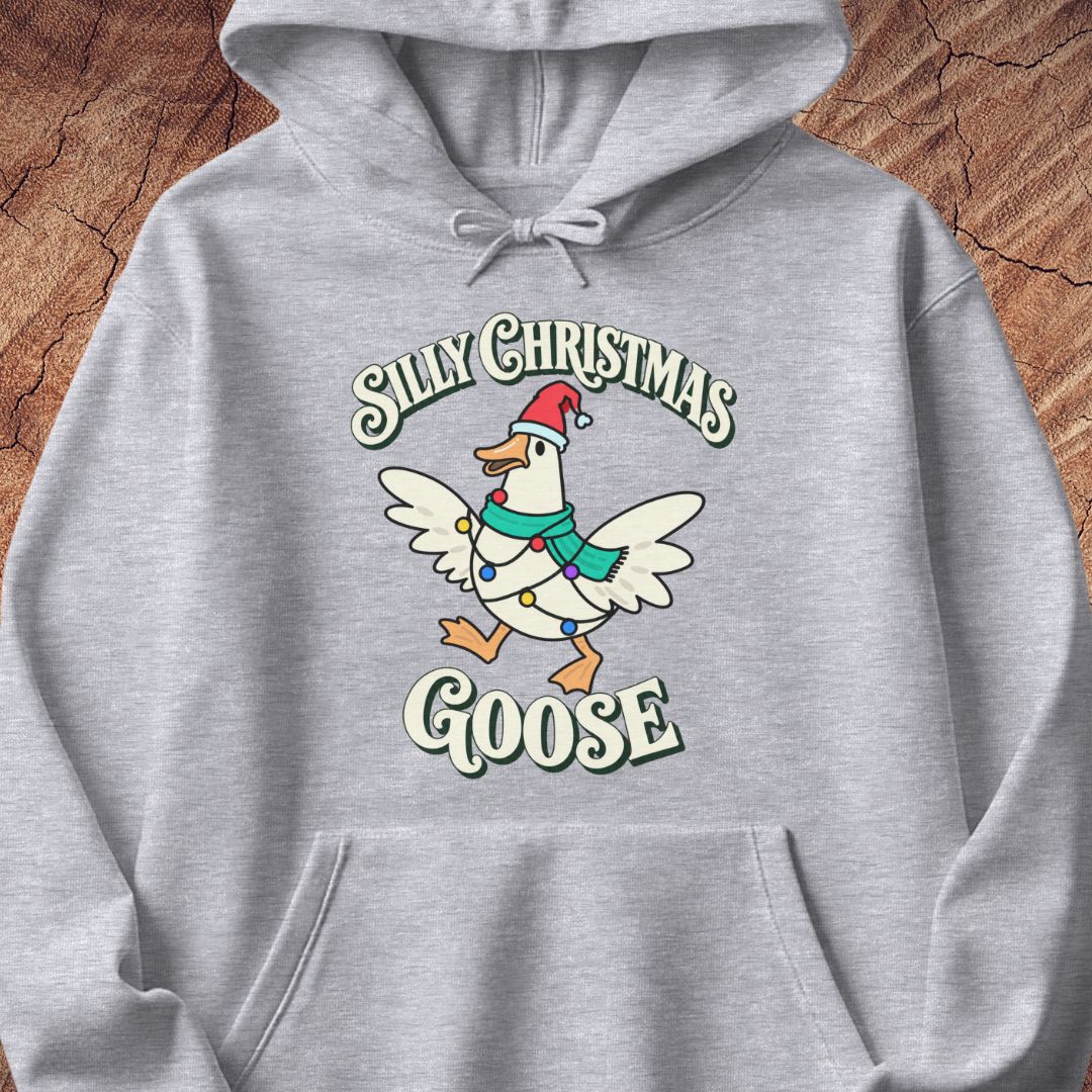 Sport grey hoodie with a goose in a Santa hat and teal scarf, wrapped in colorful Christmas lights under retro Silly Christmas Goose lettering, laid flat on a rustic wood background.