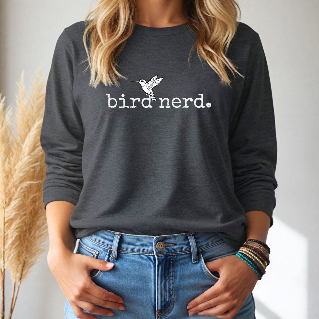 Person wearing a dark gray long sleeve shirt with 'bird nerd' text and a bird illustration, standing against a neutral background.
