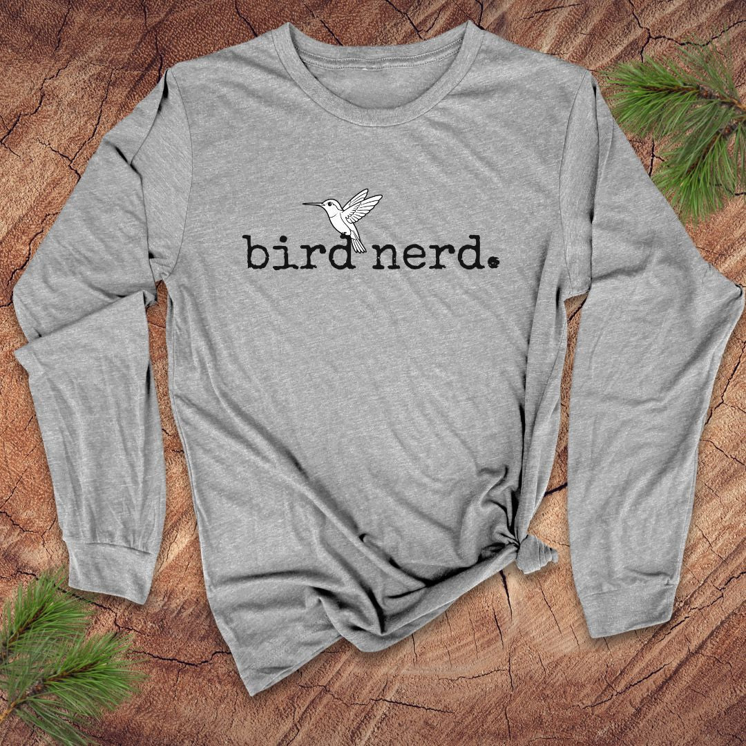 Gray long-sleeve shirt with 'bird nerd' text and bird graphic on a wooden surface.