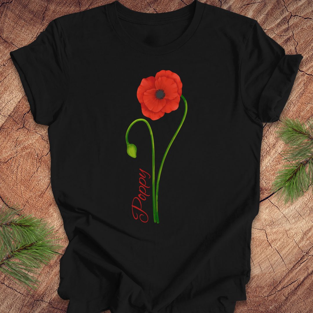 Black t-shirt with a red flower and green leaves design on a wooden surface.