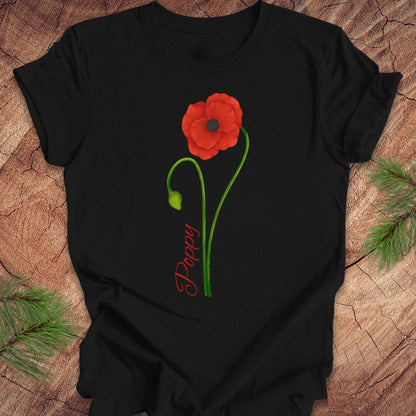 Black t-shirt with a red flower and green leaves design on a wooden surface.