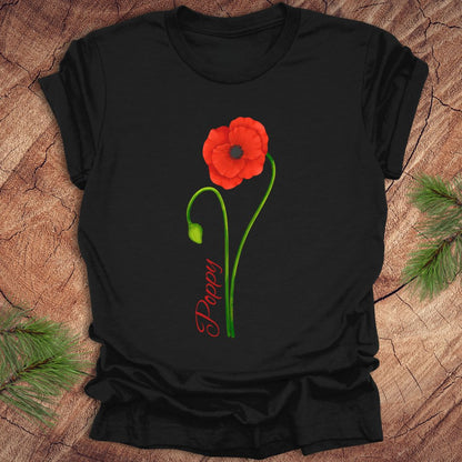 Black t-shirt with a red poppy flower design on a wooden surface