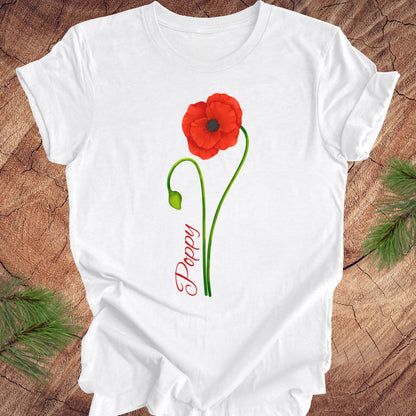 White t-shirt with a red poppy flower design on a wooden surface