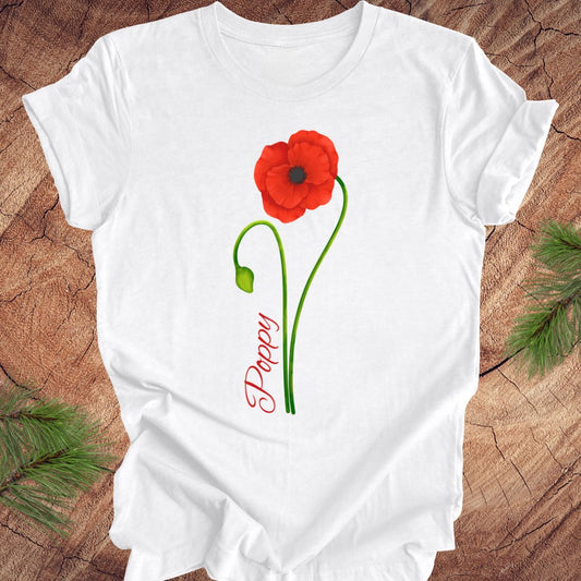 White t-shirt with a red poppy flower design on a wooden surface