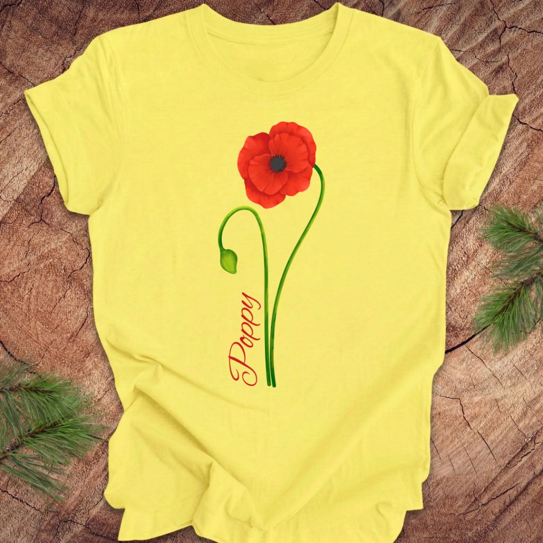 Yellow t-shirt with a red poppy flower design on a wooden surface