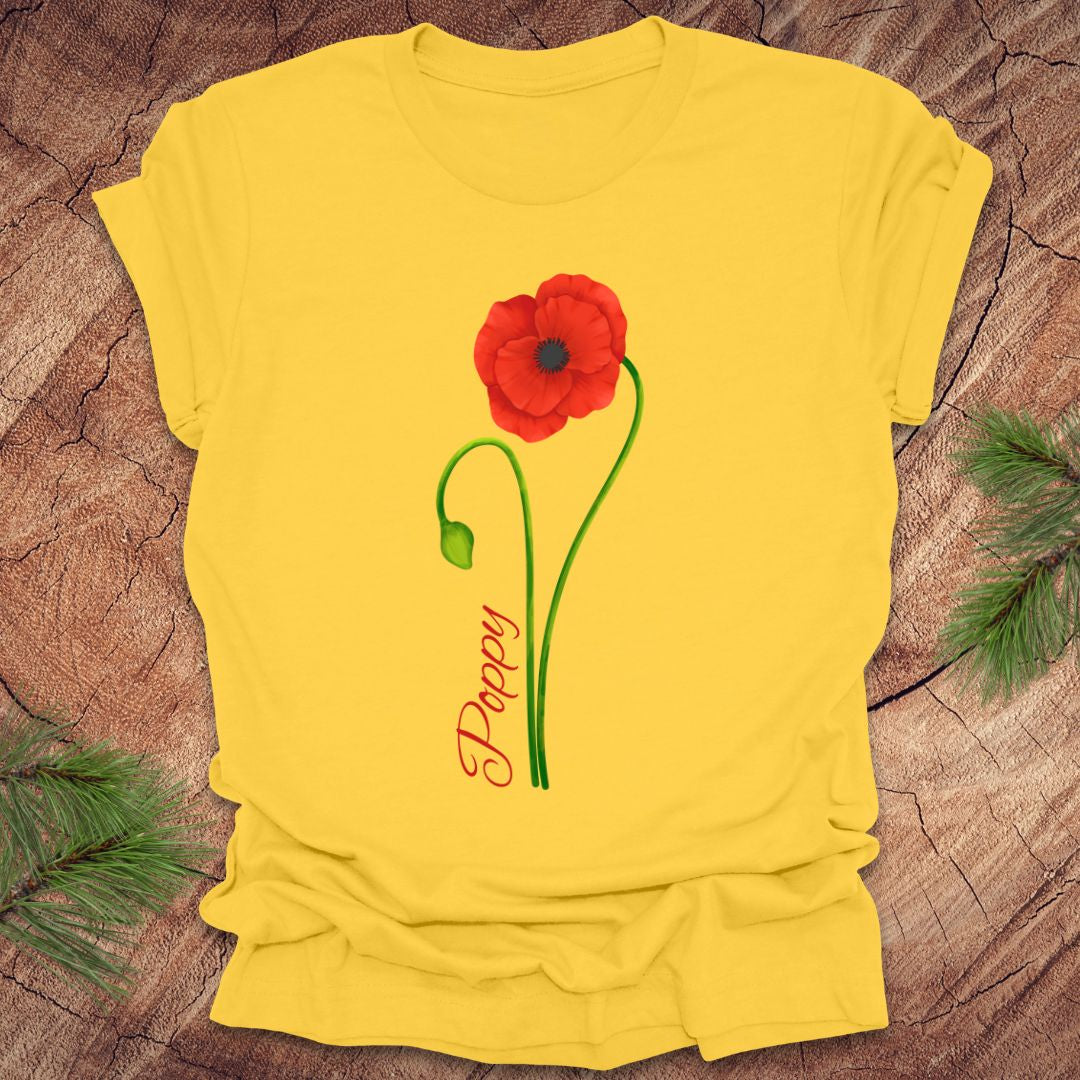 Yellow t-shirt with a red poppy flower design on a wooden surface