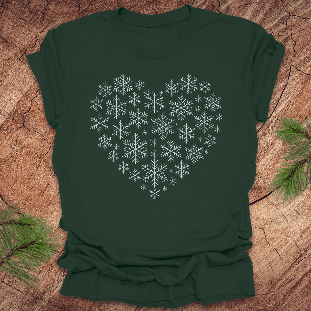 Green t-shirt with snowflakes making the shape of a heart on a wood background.