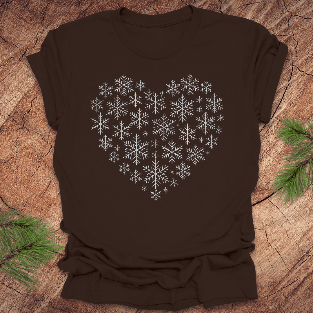 Brown t-shirt with snowflakes making the shape of a heart on a wood background.