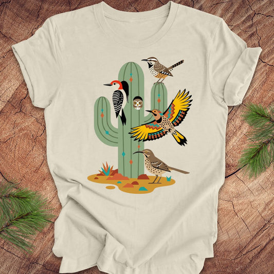 Beige t-shirt with a cactus and birds design on a wooden surface