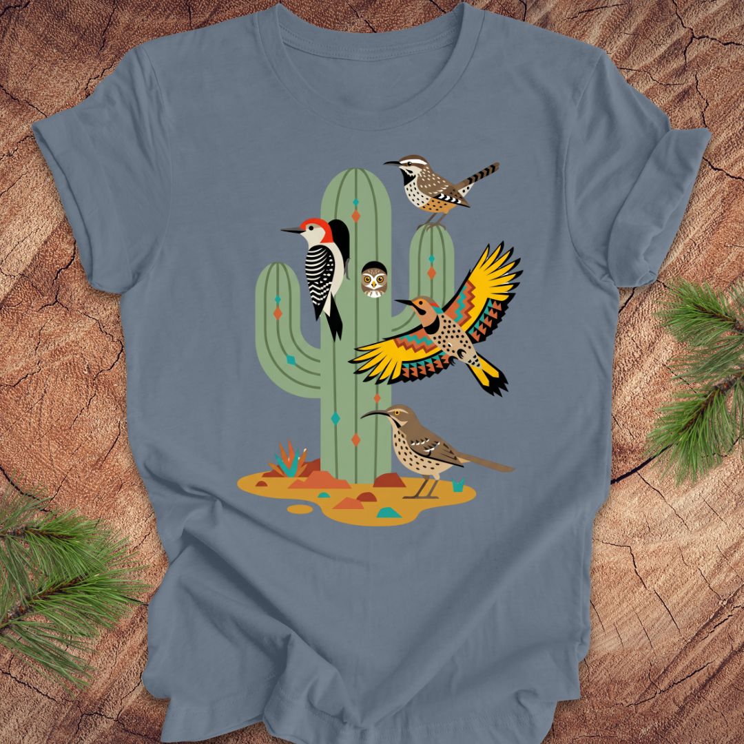 Blue t-shirt with a cactus and birds design on a wooden surface