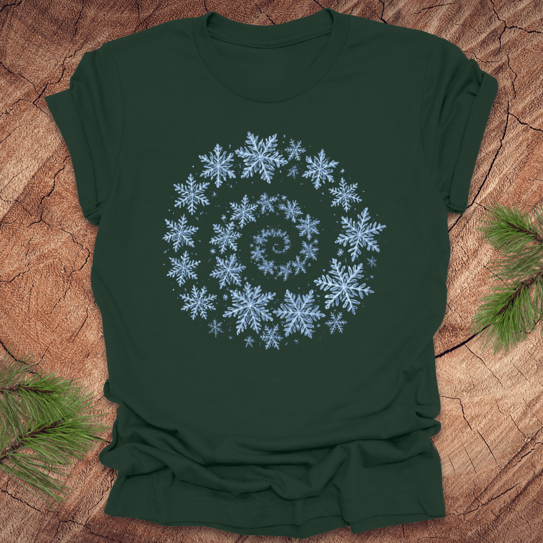 Green t-shirt with a spiral pattern of snowflakes on a wooden surface.