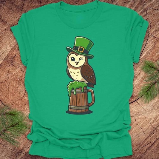 Green t-shirt with an owl design wearing a leprechaun hat on a wooden surface