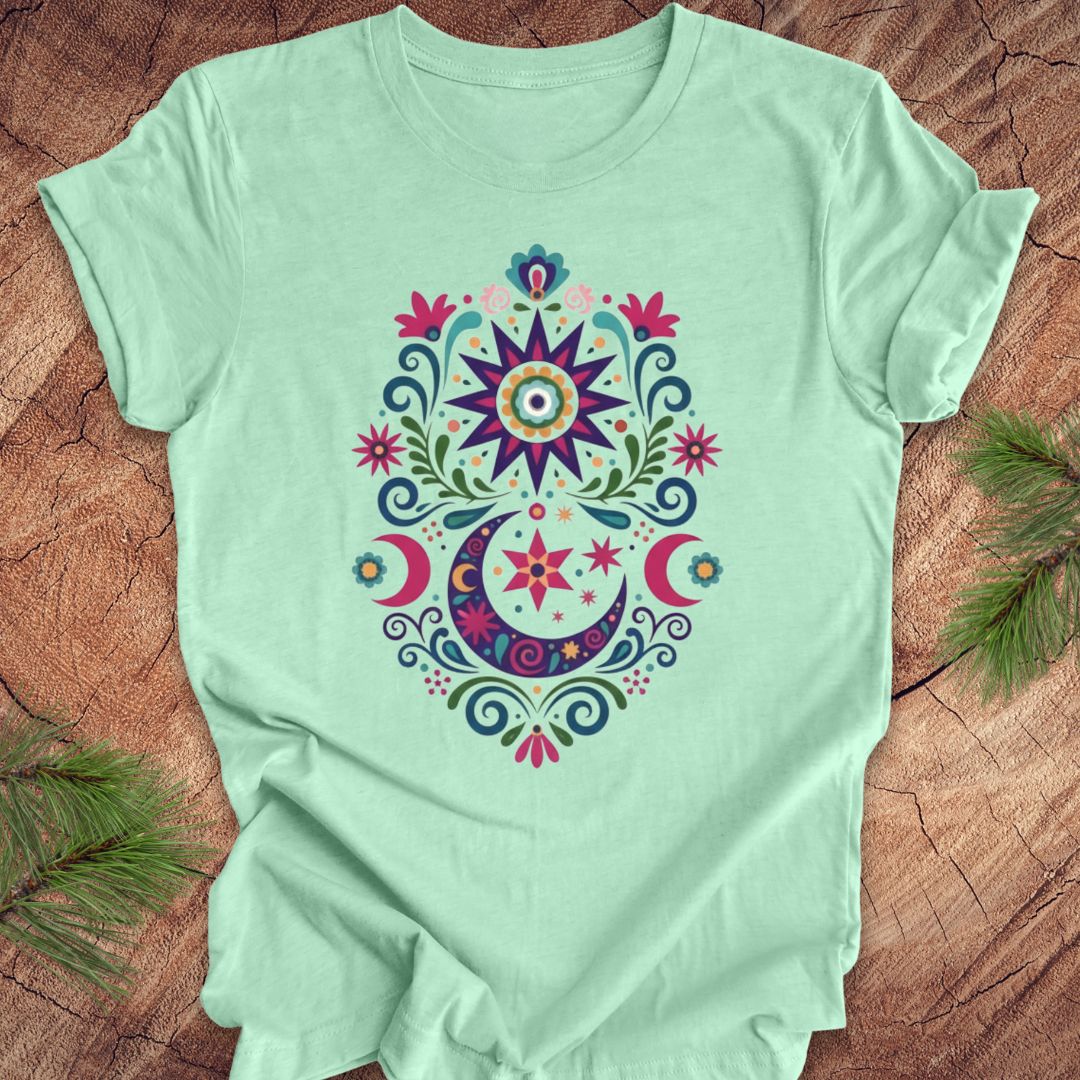 Mint green t-shirt with a colorful mandala design on a wooden surface.