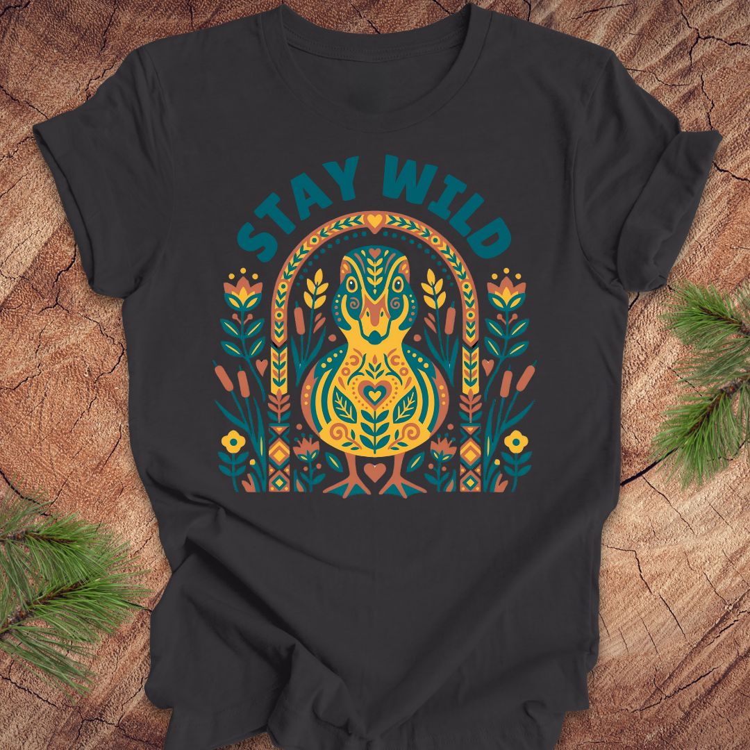 Dark gray t-shirt with colorful duck graphic and 'Stay Wild' text on a wooden surface.