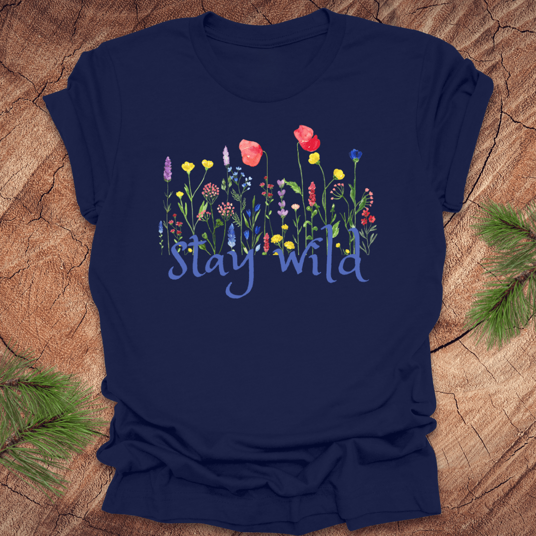 Navy blue tshirt with the text, 'stay wild' with wildflowers on a wooden background.
