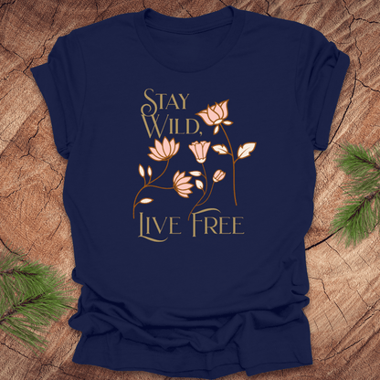 Navy blue t-shirt with floral design and text 'Stay Wild, Live Free' on a wooden surface.