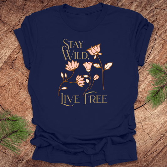 Navy blue t-shirt with floral design and text 'Stay Wild, Live Free' on a wooden surface.