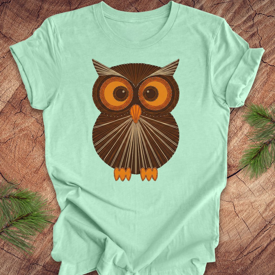 Mint green colored t-shirt with a vintage owl design on a wooden surface