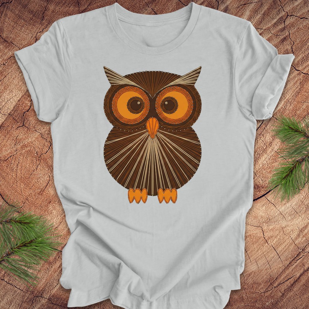 Gray colored t-shirt with a vintage owl design on a wooden surface