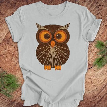 Gray colored t-shirt with a vintage owl design on a wooden surface