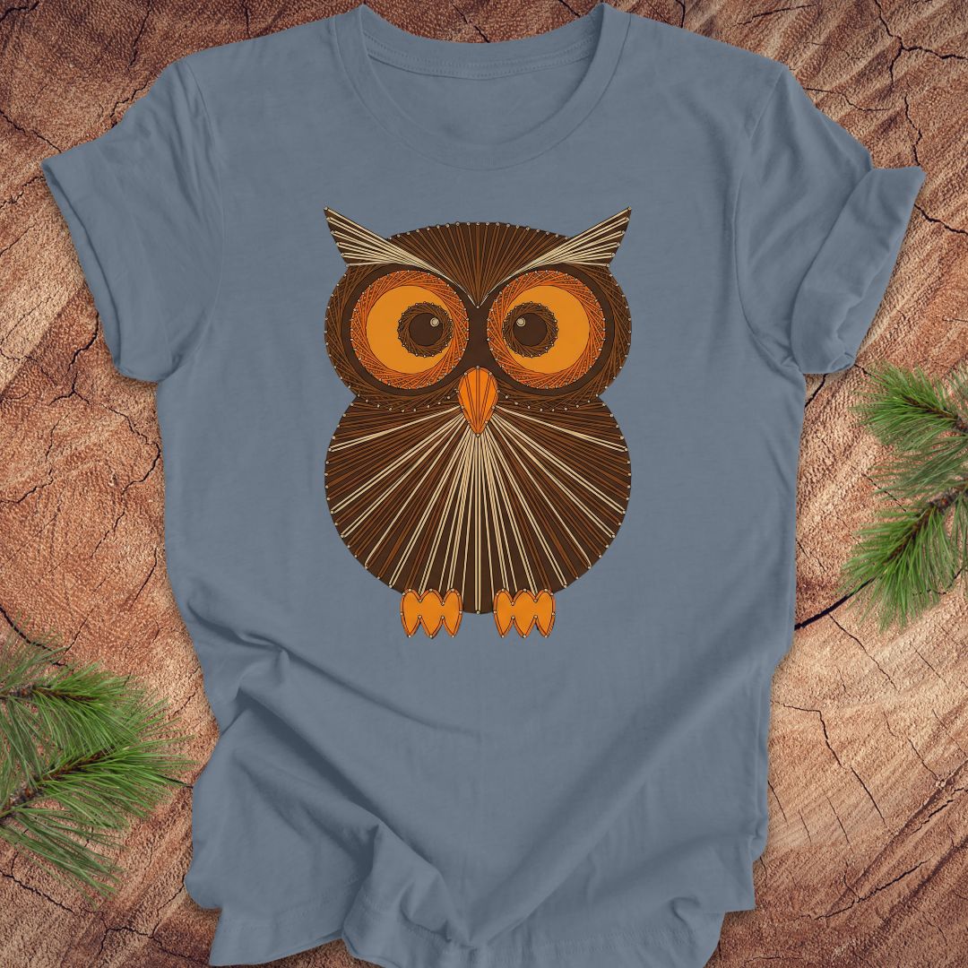 Steel blue colored t-shirt with a vintage owl design on a wooden surface