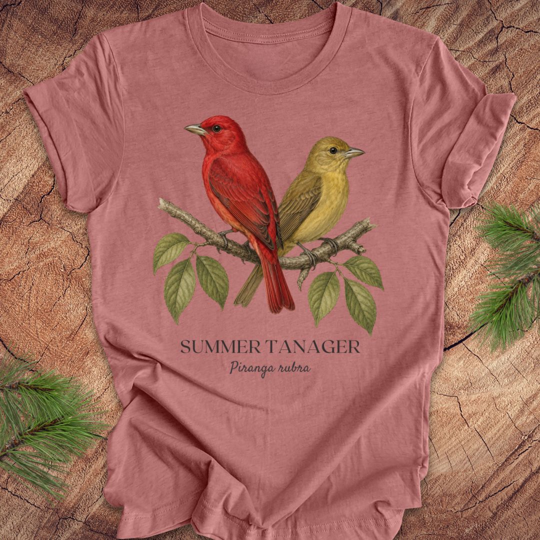 Mauve t-shirt with male and female summer tanager bird illustration on a wooden surface