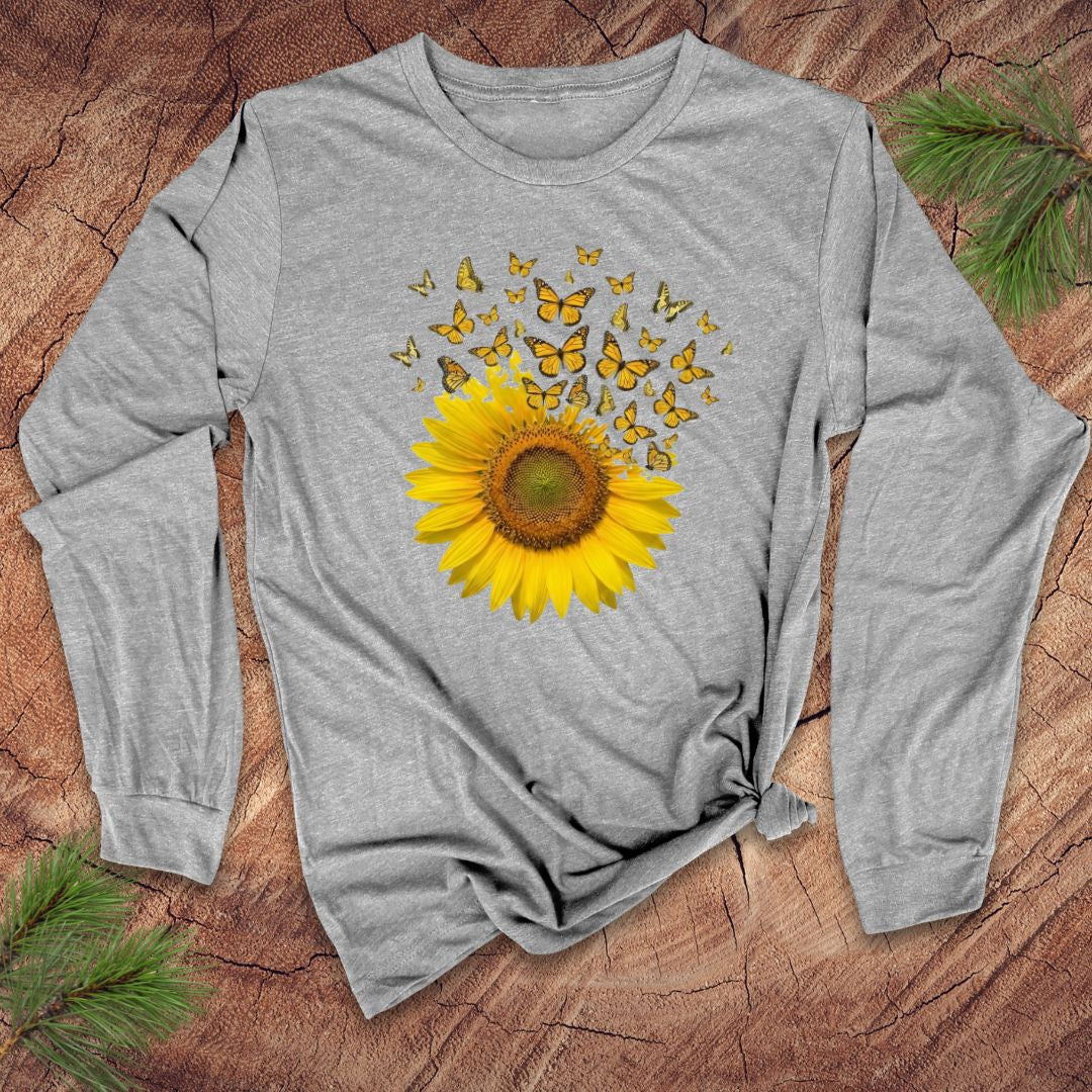 Gray long-sleeve shirt with a sunflower and butterfly design on a wooden surface.